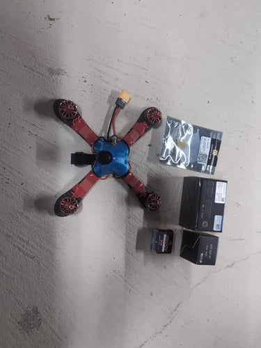 Red and blue quadcopter freestyle racing drone with four propellers, top view