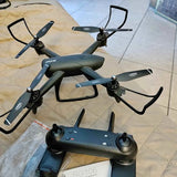 Foldable quadcopter drone with four propellers and front camera module