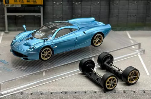 Blue diecast sports car model with black replacement wheels and rear spoiler