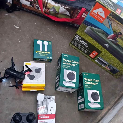 Drone accessories bundle with boxed cameras, charging cords, and a small black drone