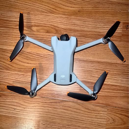 DJI Mini 3 drone with four black propellers and light gray body