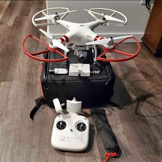 White quadcopter drone with red prop guards and white remote controller