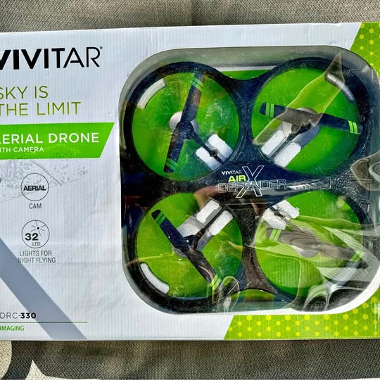 Green quadcopter drone in retail packaging, four-blade propellers