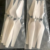Drone propeller set with four white blades and black hub, in clear protective packaging