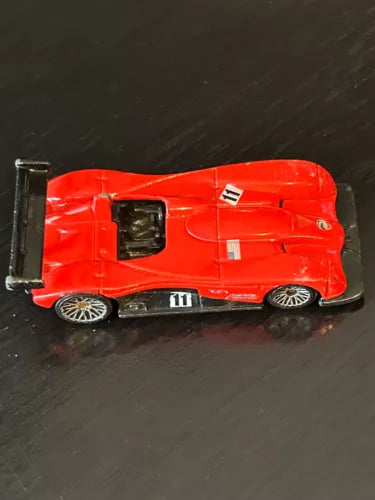 Hot Wheels red diecast roadster with open cockpit and black wheels