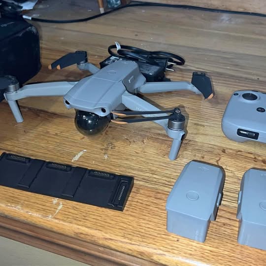 DJI Mavic 2 drone with gray body, propellers, and batteries on a table