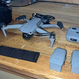 DJI Mavic 2 drone with gray body, propellers, and batteries on a table