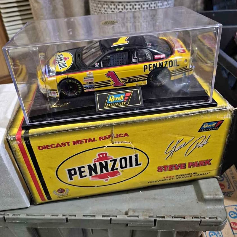 Yellow and black #1 Pennzoil NASCAR diecast car model in clear display case