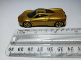 Gold 1:64 die-cast model car, side view, with black interior and gold wheels