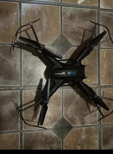 Black quadcopter drone with camera, four propellers and front display