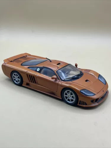 Copper orange diecast sports car model with blue stripes, 1:18 scale, black hood.