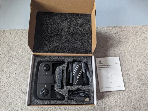 Mini quadcopter drone set with camera and remote, in open packaging