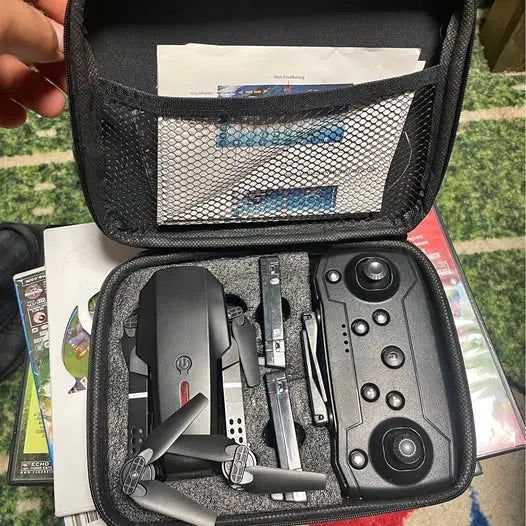 Black drone carrying case with remote controller and folded quadcopter