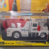 White diecast tow truck model with chrome wheels and red emergency light, front 3/4 view
