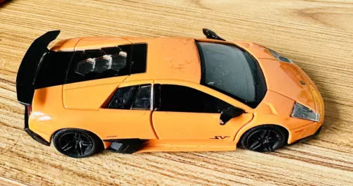 Orange diecast Lamborghini model car with black accents and openable hood
