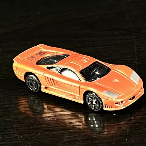 Orange diecast sports car with black windshield and silver side stripes, 1:64 scale