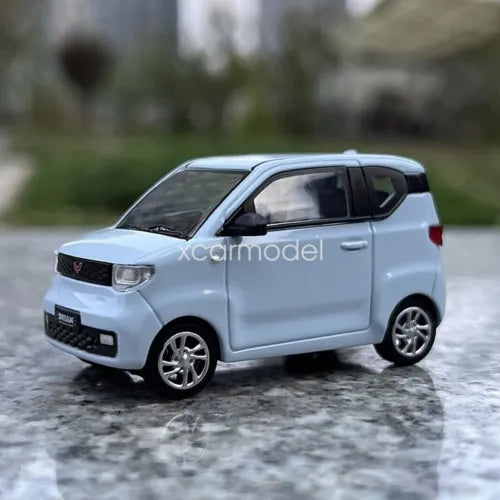 Light blue 1/64 scale diecast car model, compact hatchback, front three-quarter view