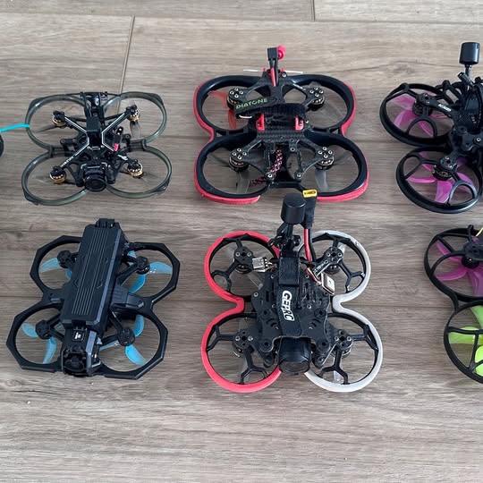 FPV drone quadcopter with black frame, four propellers, and red accents