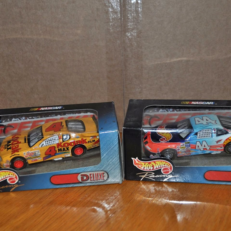 Diecast NASCAR toy cars in blue and multicolor blister packaging, Hot Wheels logos