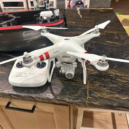 White DJI Phantom 3 Standard drone with controller and camera on a desk
