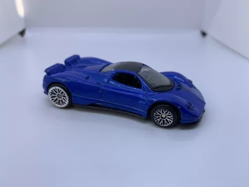 Blue diecast sports car model with black window and silver wheels, side view