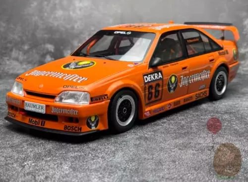 Orange race car diecast model, front 3/4 view with racing decals and wheels
