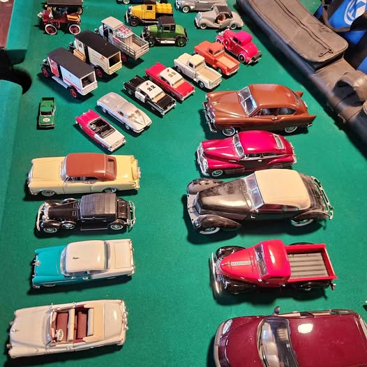 Assorted diecast toy cars, mixed colors and styles on a display surface