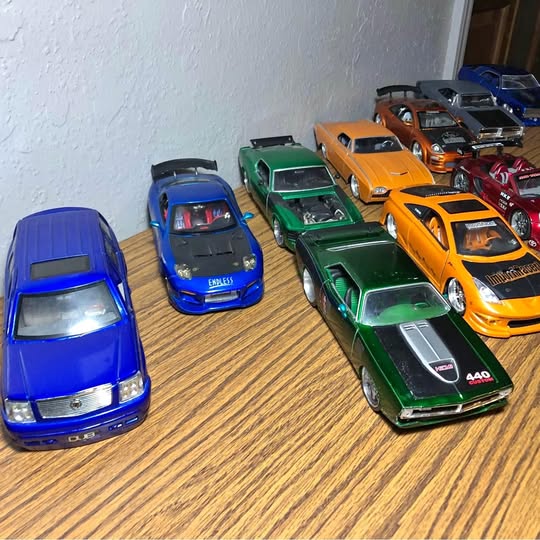 Assorted 1/18 scale diecast toy race cars, blue, green, orange, yellow, red