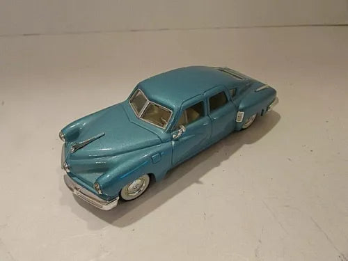 Blue diecast classic car with chrome bumper, front three-quarter view, 1:43 scale