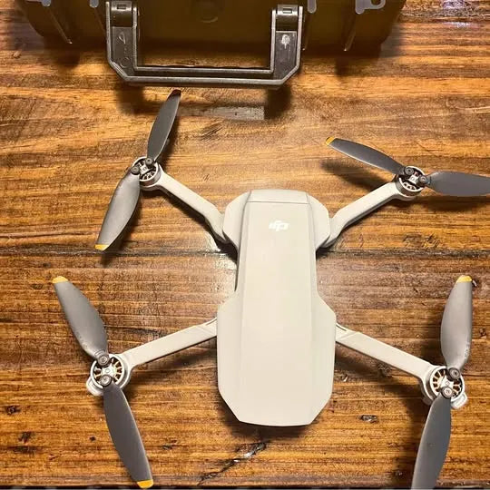 White DJI Fly drone with four propellers and central body