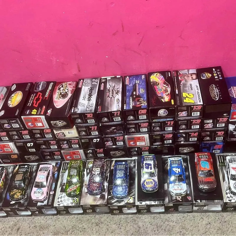 Diecast car collection in display boxes, multiple racing cars shown in rows
