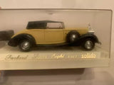 Gold and black diecast car model with detailed wheels, in display box