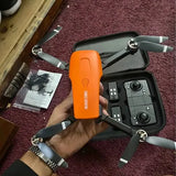 Orange and gray quadcopter drone with foldable propellers