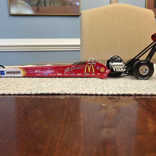 Die-cast top fuel dragster model, red body with black front wheels and McDonald's logo