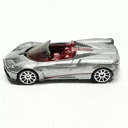Silver 1/64 diecast roadster with open cockpit and red interior, detailed wheels