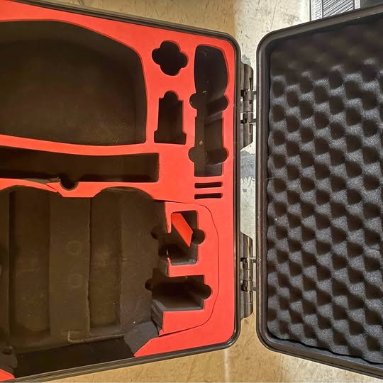 Drone hard case with orange lid and black foam inserts