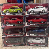 Sealed 1:24 diecast car lot in boxes, showing green, white, and red vehicles
