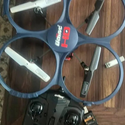 Grey quadcopter drone with four propellers and camera on body