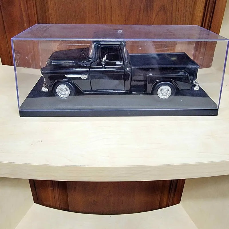Black diecast pickup truck model in clear display case