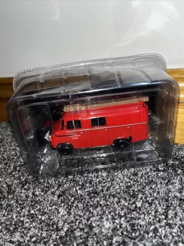 Red diecast fire truck model in clear plastic case, front view