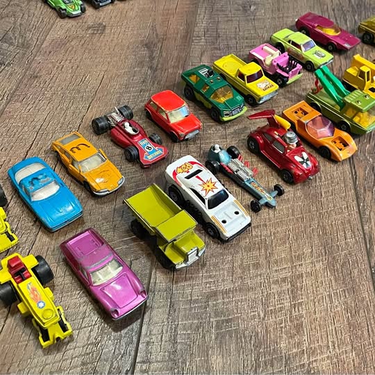 Diecast toy cars in assorted colors, multiple models arranged together.