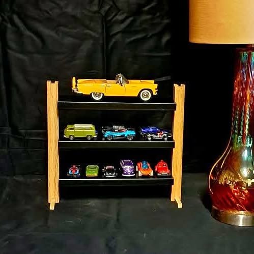 Diecast display stand with wooden frame, black shelves, and multiple toy cars