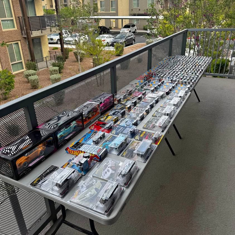 Assorted diecast toy car lot in blister packs on display table