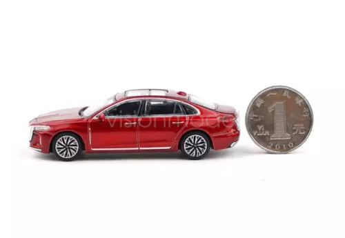 Red 1:64 diecast sedan model toy car, side view beside a coin