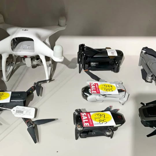 White quadcopter drone with propellers and front camera module