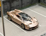 Gold 1:64 diecast sports car with black windshield and rear wing