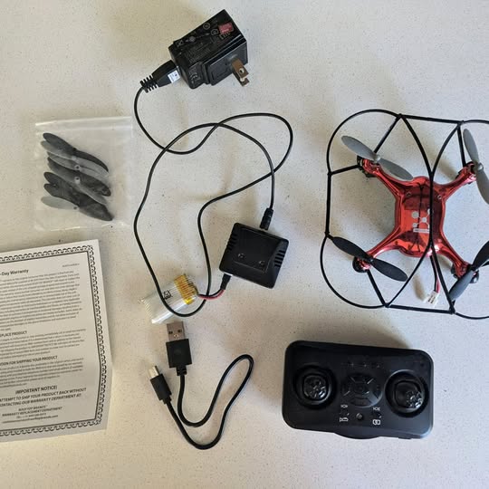 Red quadcopter drone with controller and connected cables