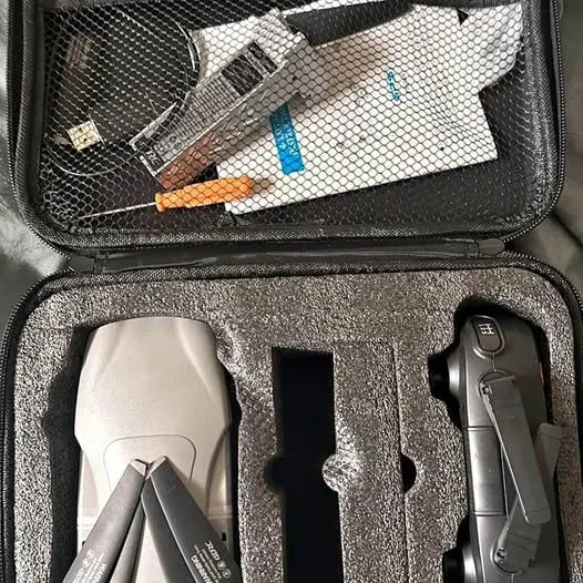 Hard-shell drone case with foam insert, drone body, and remote controller.