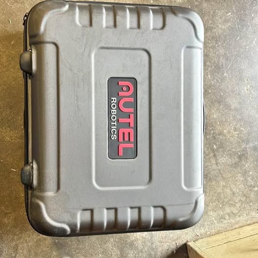 Metallic silver protective drone hard case with handle and front UTEL logo patch