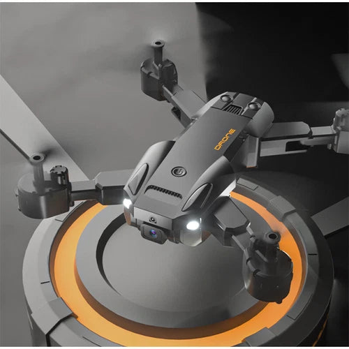 Grey quadcopter drone with front camera and LED light, above orange landing pad